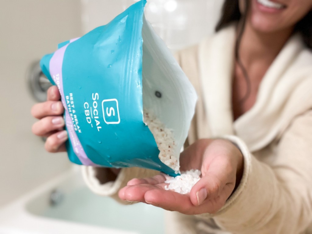 pouring bag of bath salts into hand