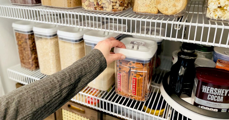 woman with hand on top of walmart food storage containers on shelf