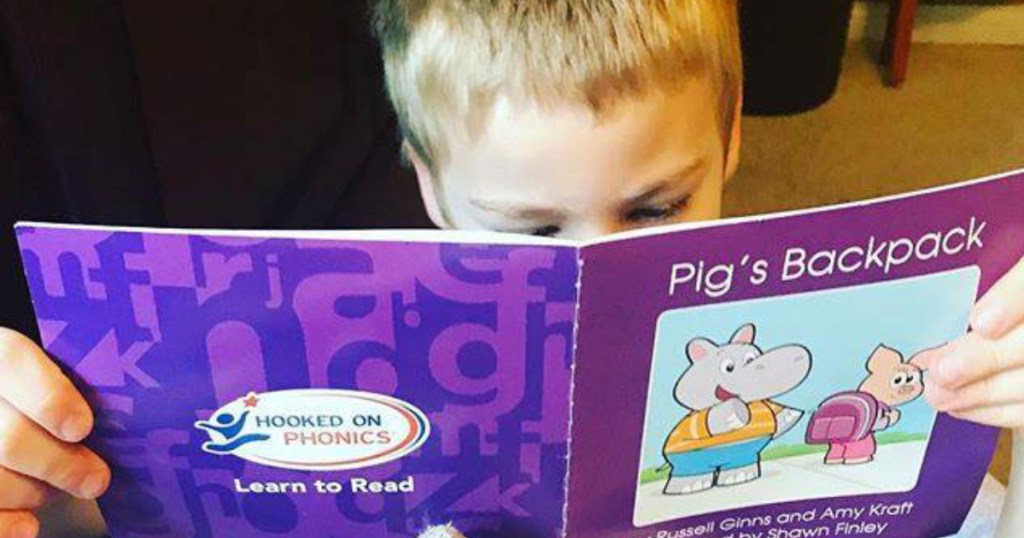 Boy reading Hooked on Phonics Book