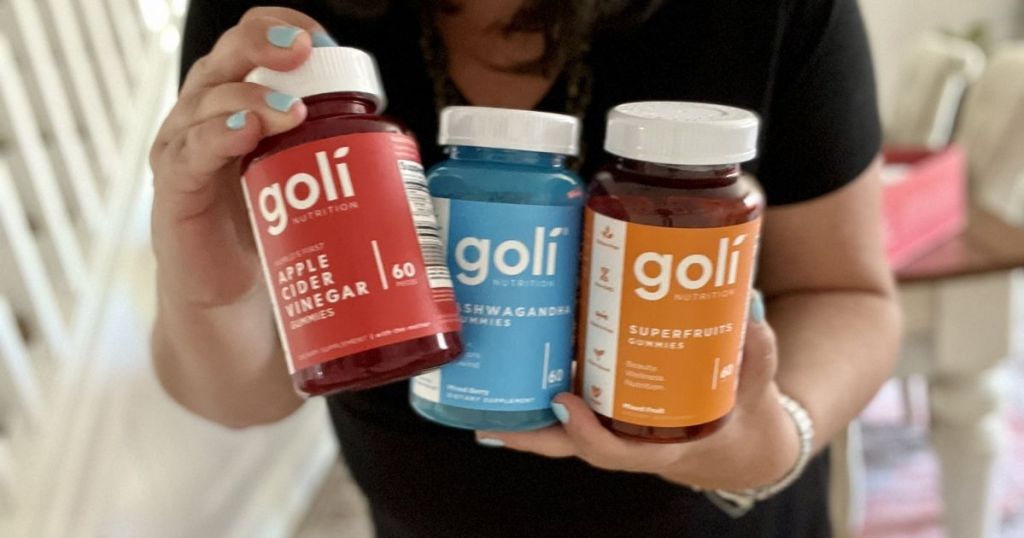 person holding three bottles of Goli gummies