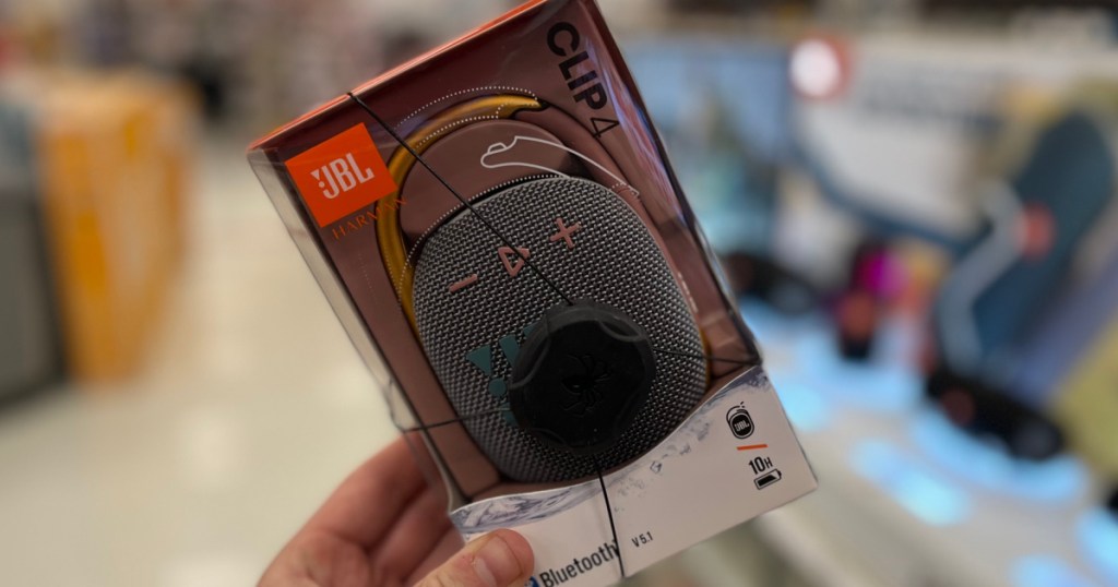 hand holding black portable speaker in package 