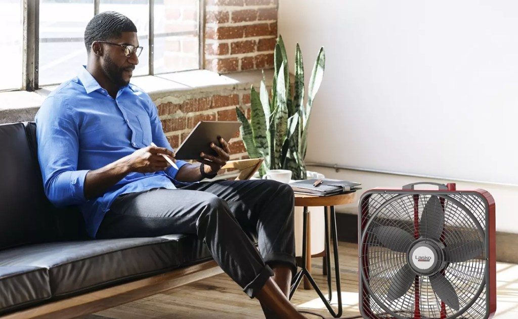 man on a tablet sitting by a fan