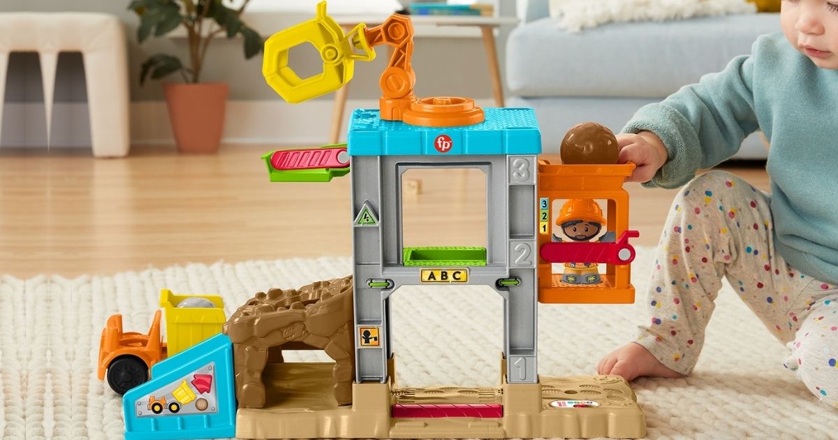 child playing with Little People Construction Set on rug