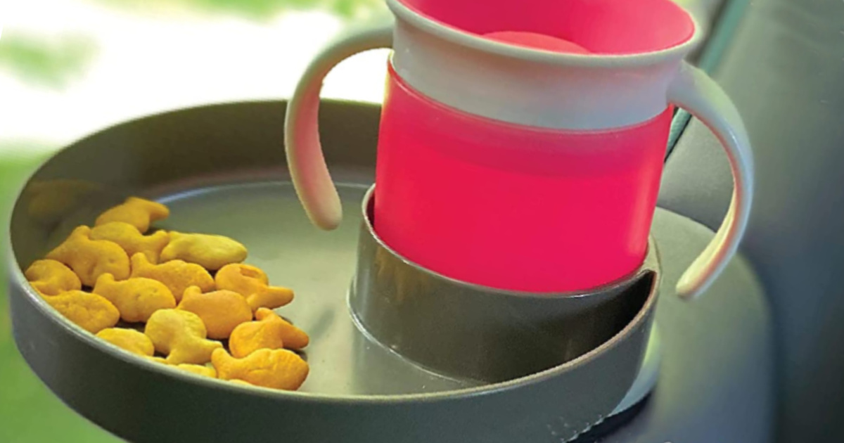 gray travel tray in car seat with snacks and pink water bottle