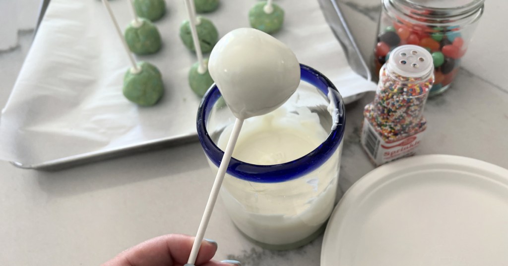 dipping cake pop into melted candy coating