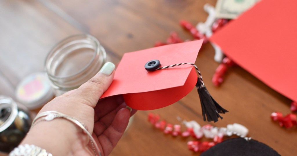 holding a paper graduation hat craft