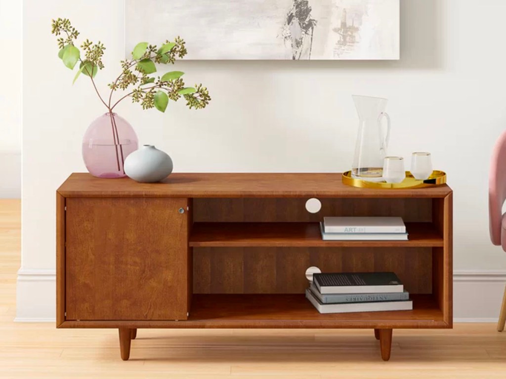 brown media console with flower and books