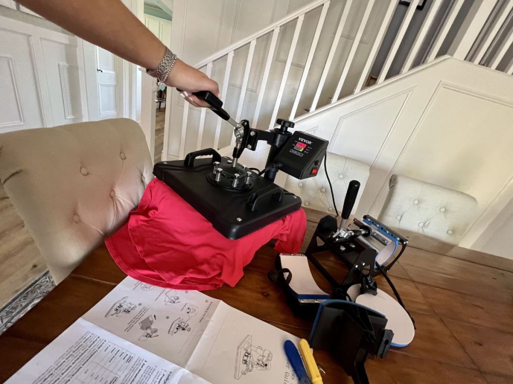 person using heat press on red tee