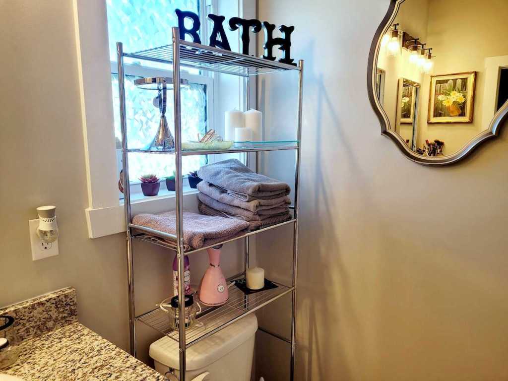 tall silver stainless steel bathroom shelves over toilet and window 