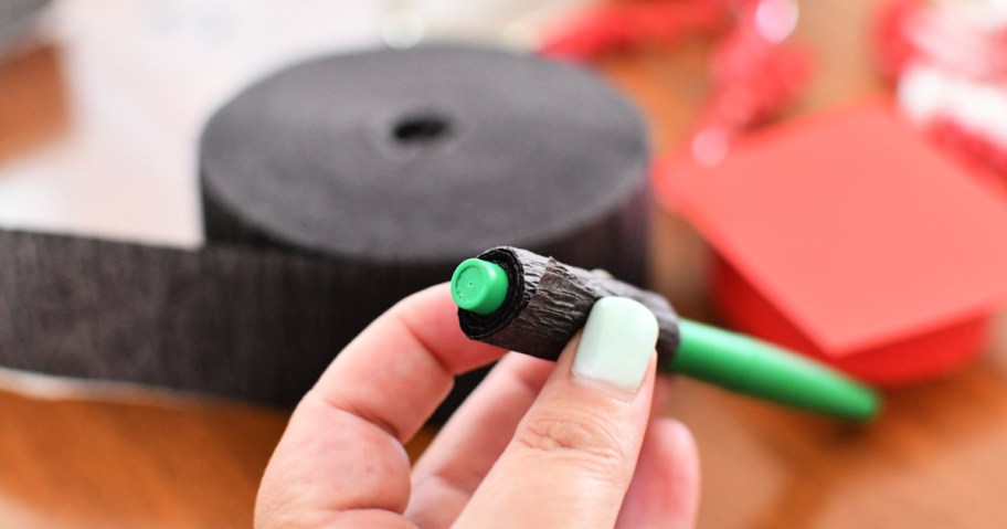 wrapping crepe paper around a pen