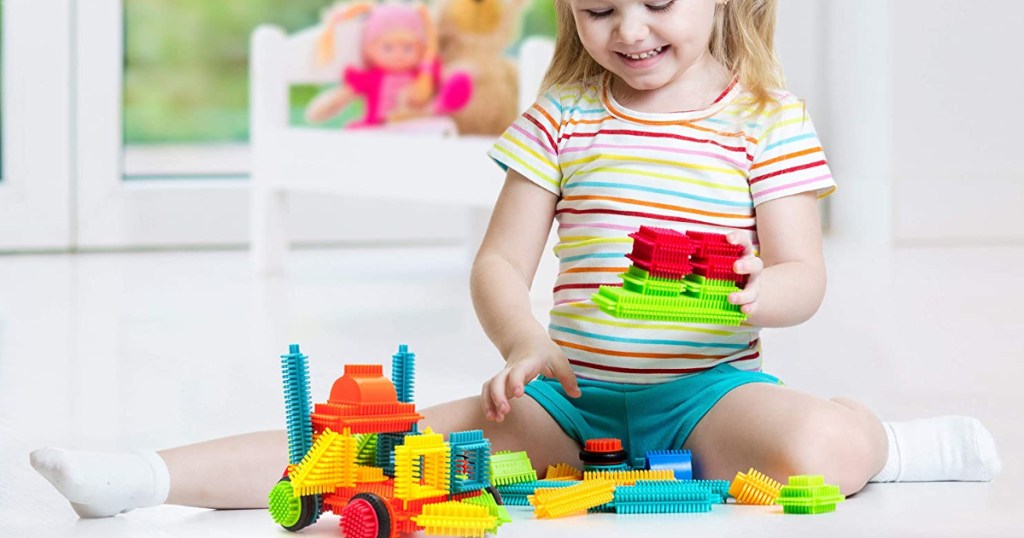Little girl building with Bristle Blocks