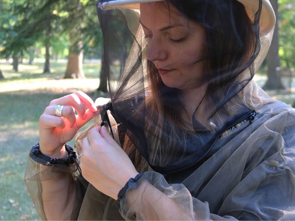 A woman wearing a bug jacket with face net