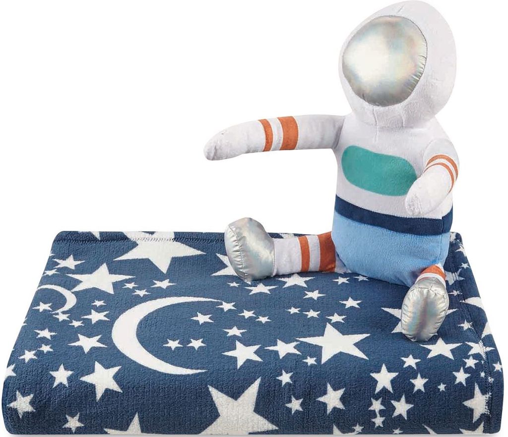 Plush astronaut toy sitting on a blanket with moons and stars