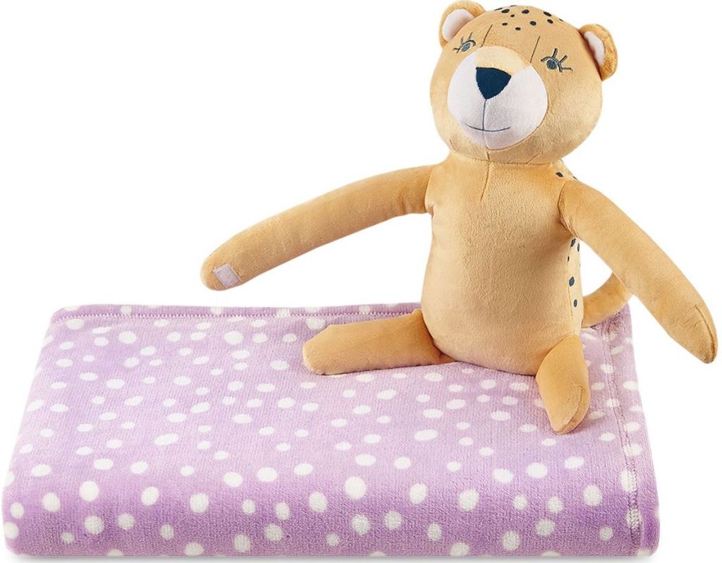 Plush leopard sitting on a purple throw with white dots