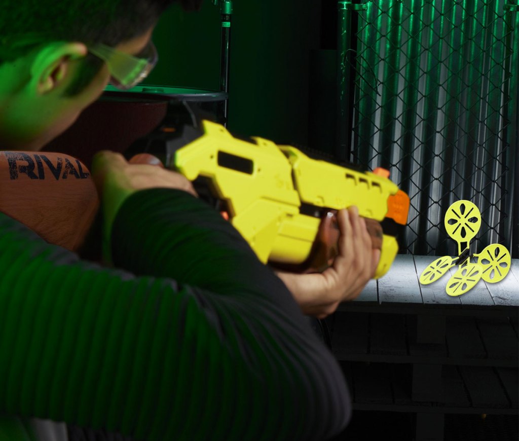 boy aiming nerf blaster at target