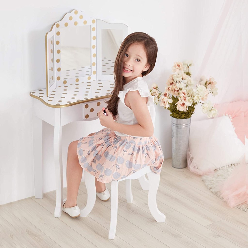 girl sitting in front of Teamson White Vanity