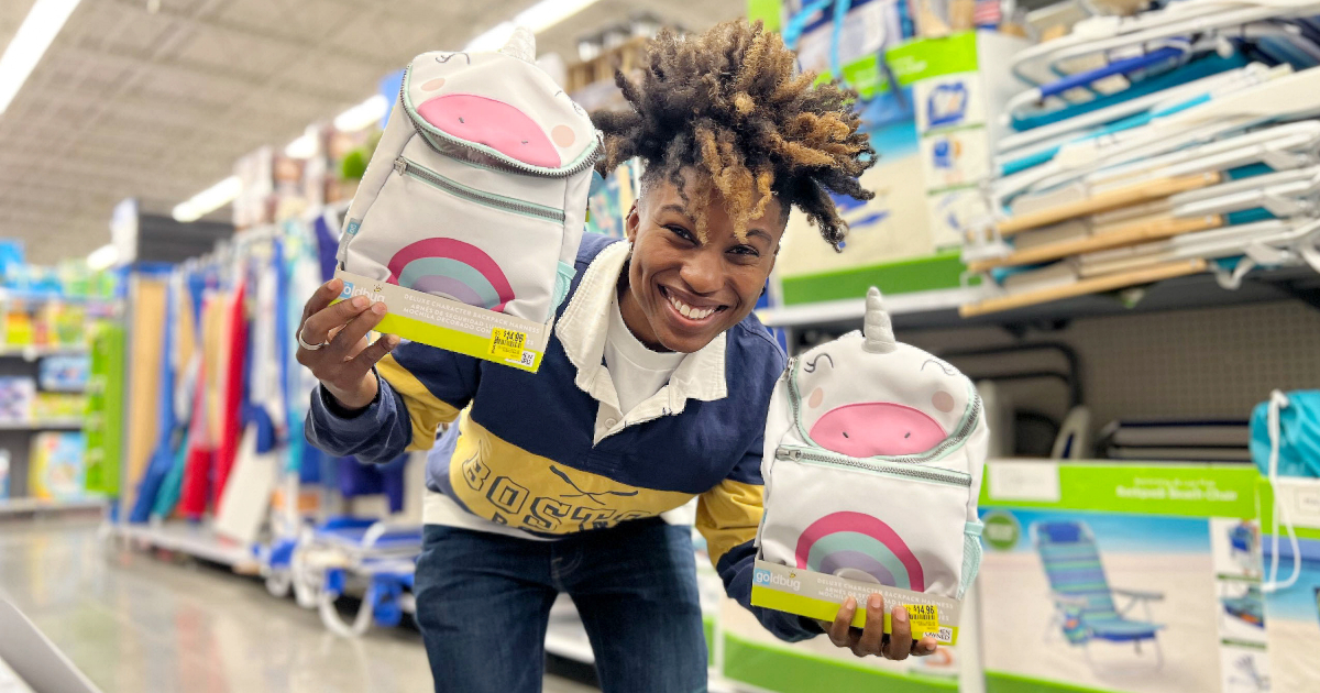 Person holding On The Goldbug Unicorn Backpack Harness with Removable Tether in a store aisle