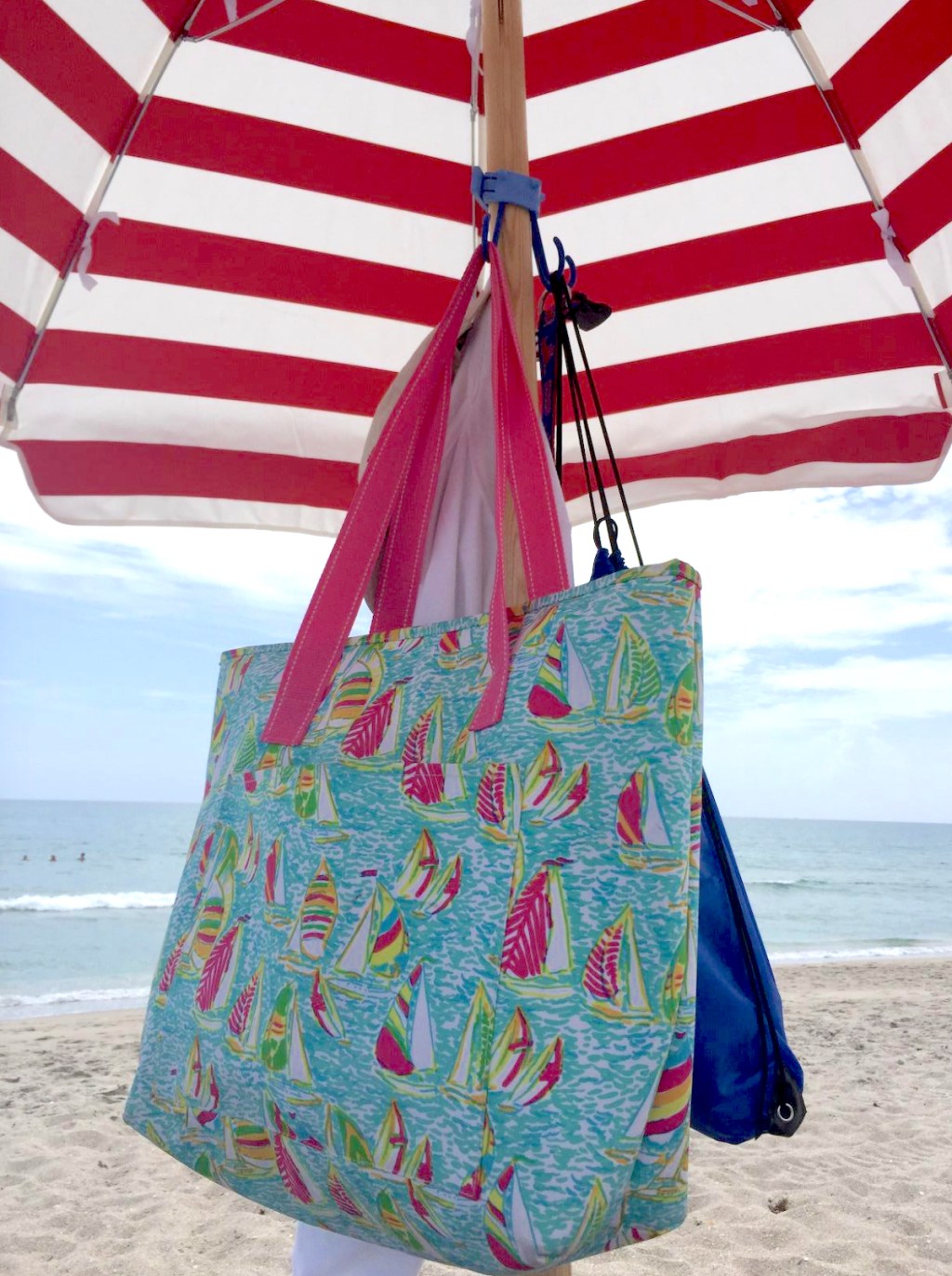 red and white stripe umbrella with hooks and bags hanging from them