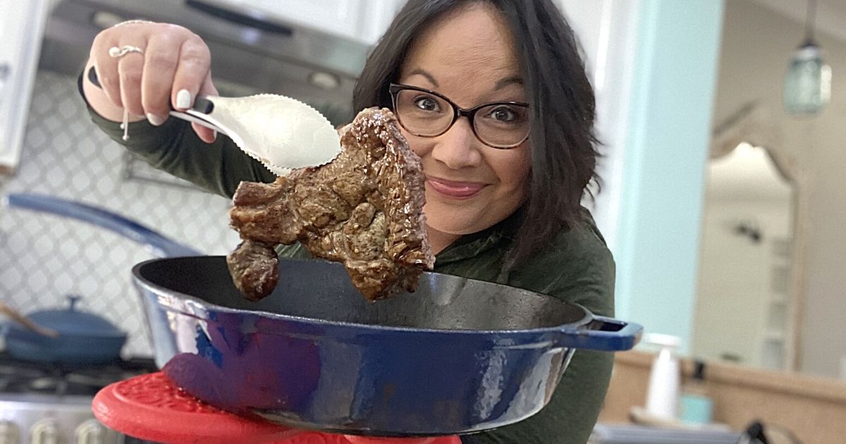 woman cooking steak in blue pan