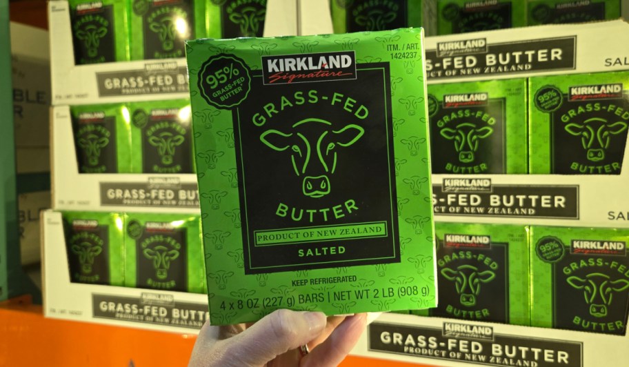 hand holding kirkland butter near freezer