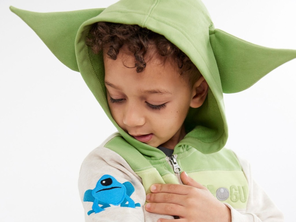 boy looking at patch on Grogu hoodie