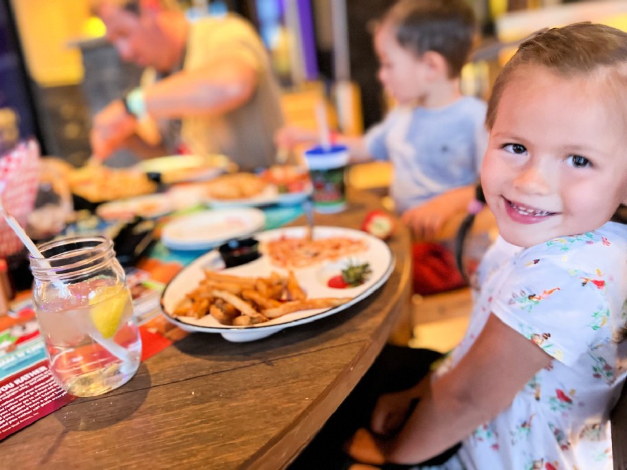 kids at table in great wolf lodge with plate of french fries and water