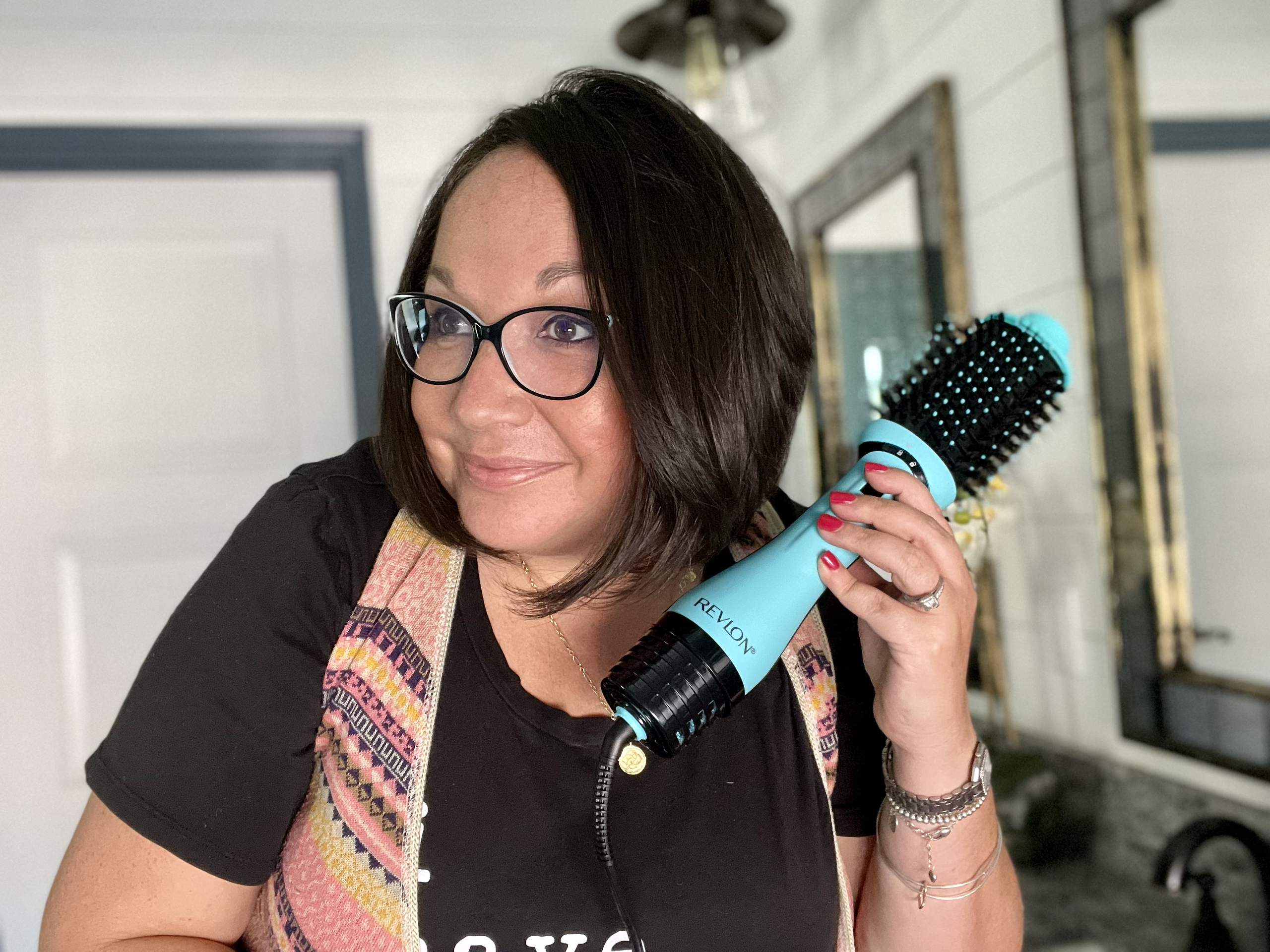 woman holding revlon blow dryer brush 2.0 next to hair