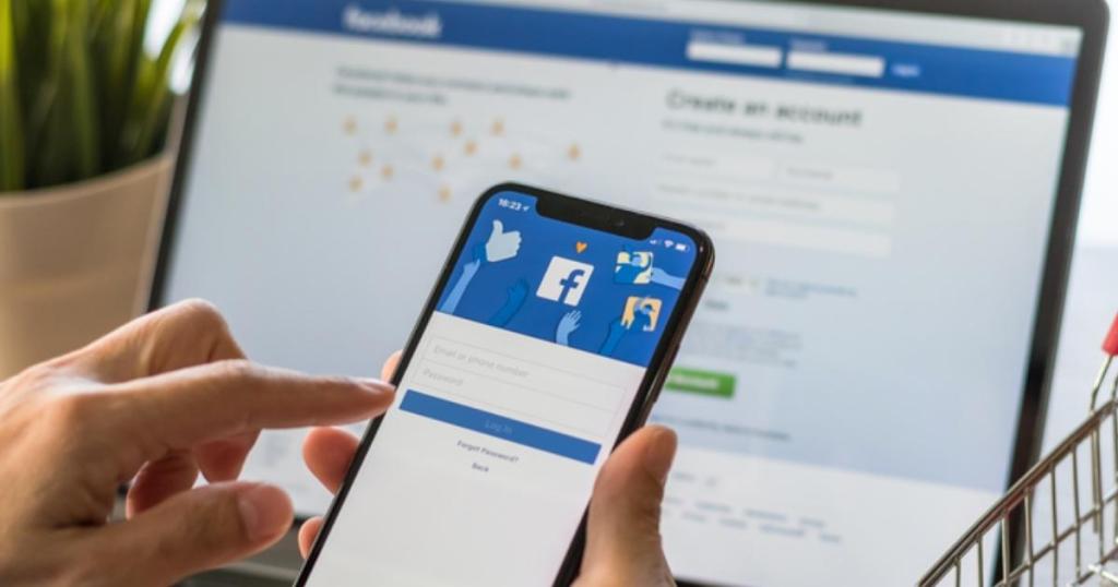 facebook login page on phone and computer in background