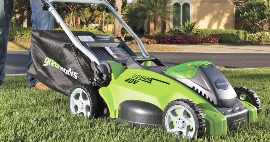 man pushing a greenworks lawn mower on grass