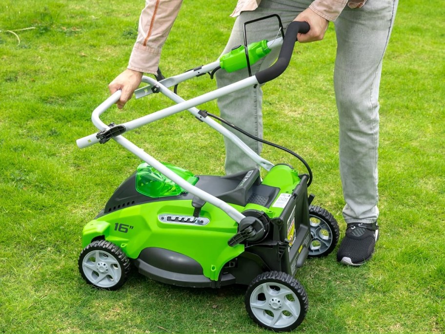 person collapsing down a greenworks lawn mower