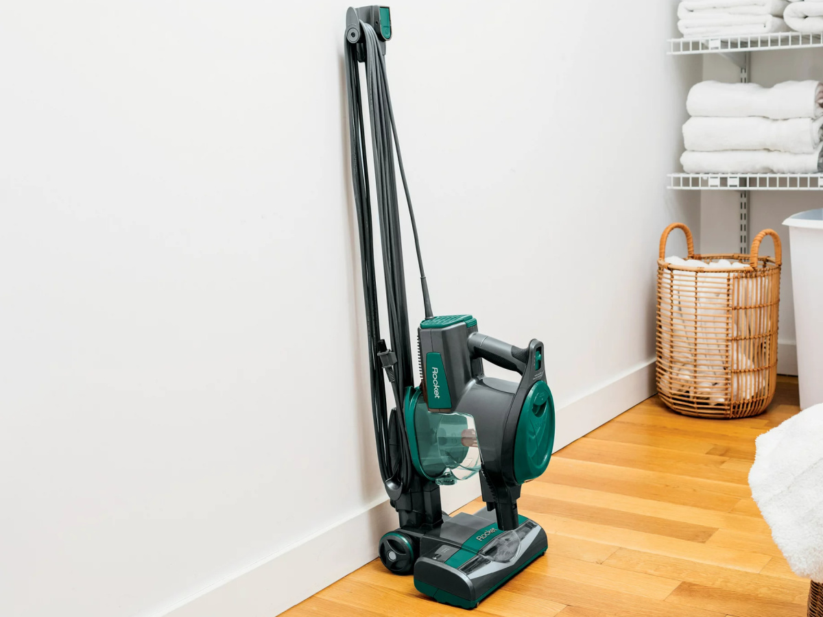 green corded stick vacuum in closet