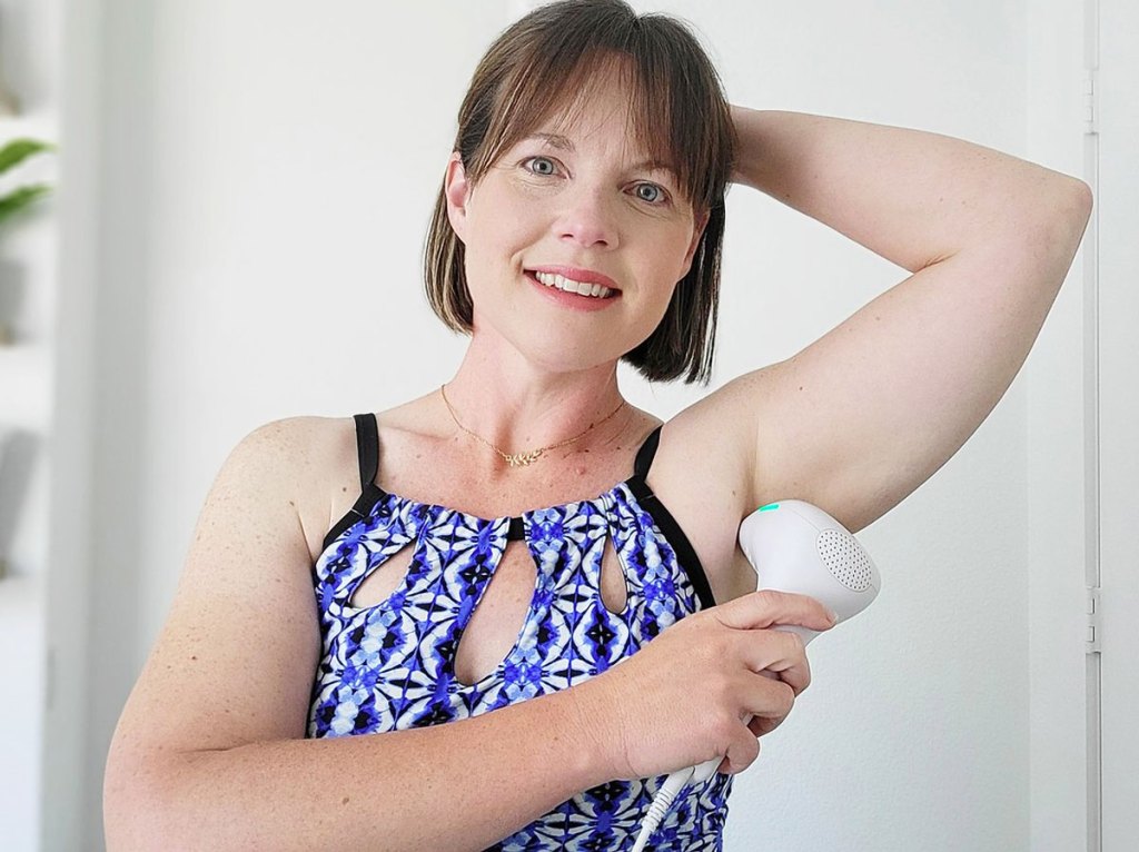 woman using laser hair remover in armpit