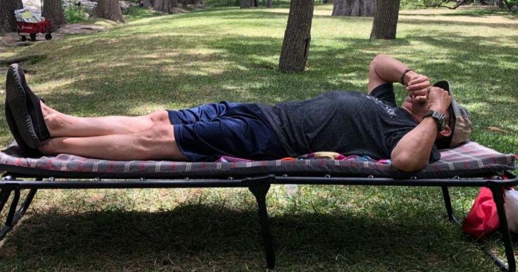 man laying on cot outdoors