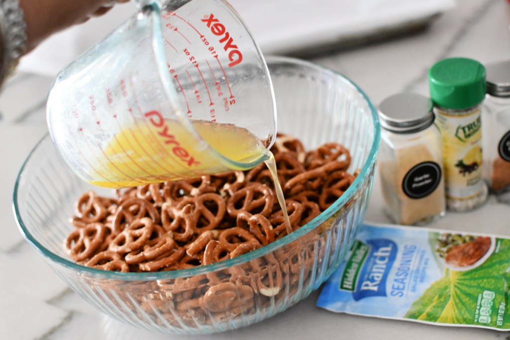 pouring melted butter on pretzels