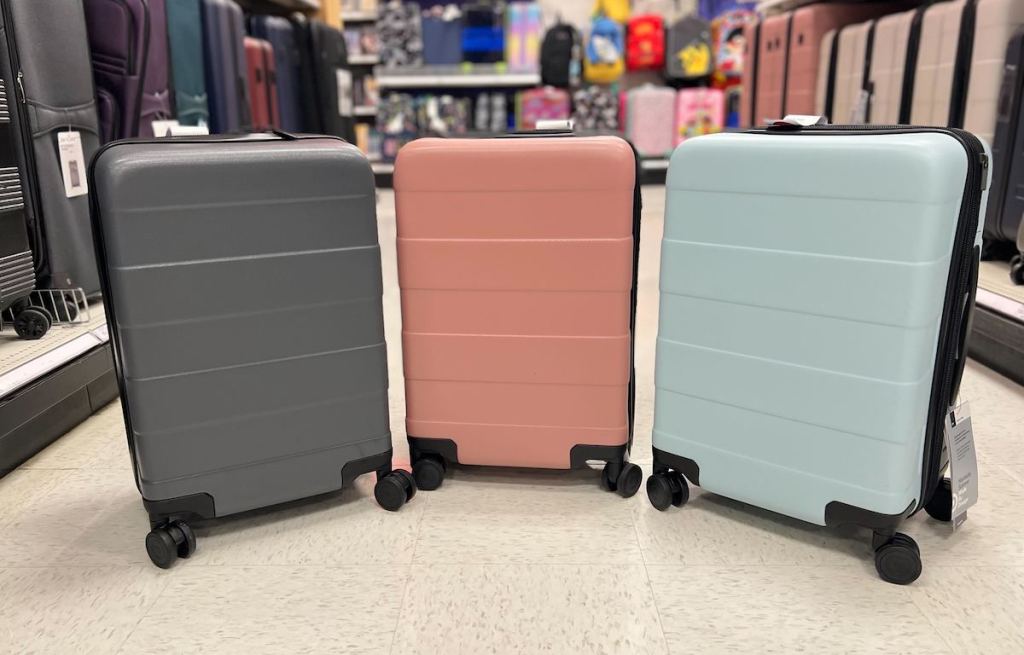 three suitcases in a row on store aisle floor