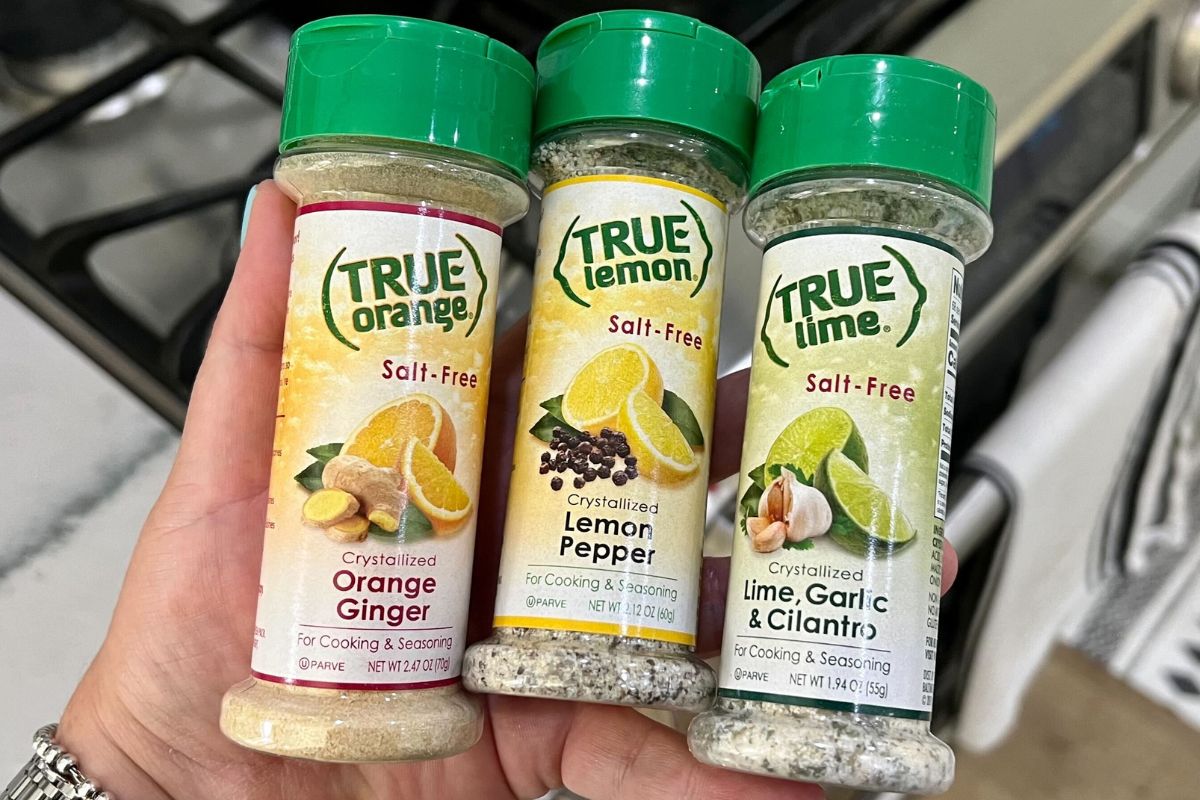 a womans hands holding 3 true seasoning blend bottles