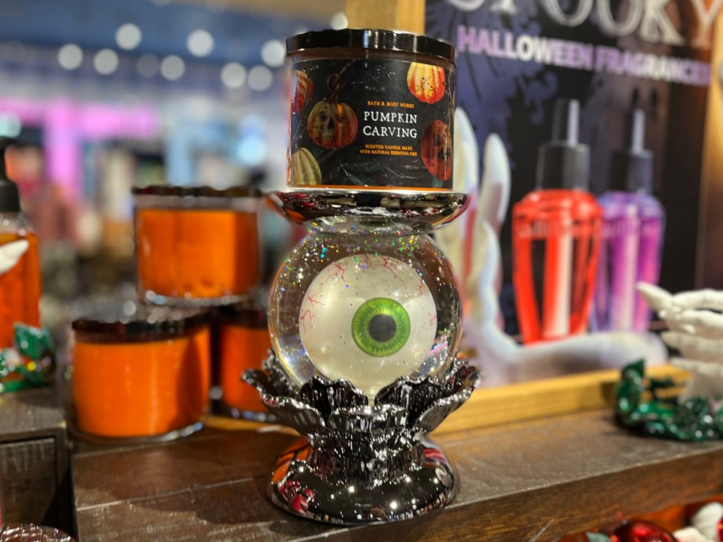 pumpkin candle on eyeball pedestal in store