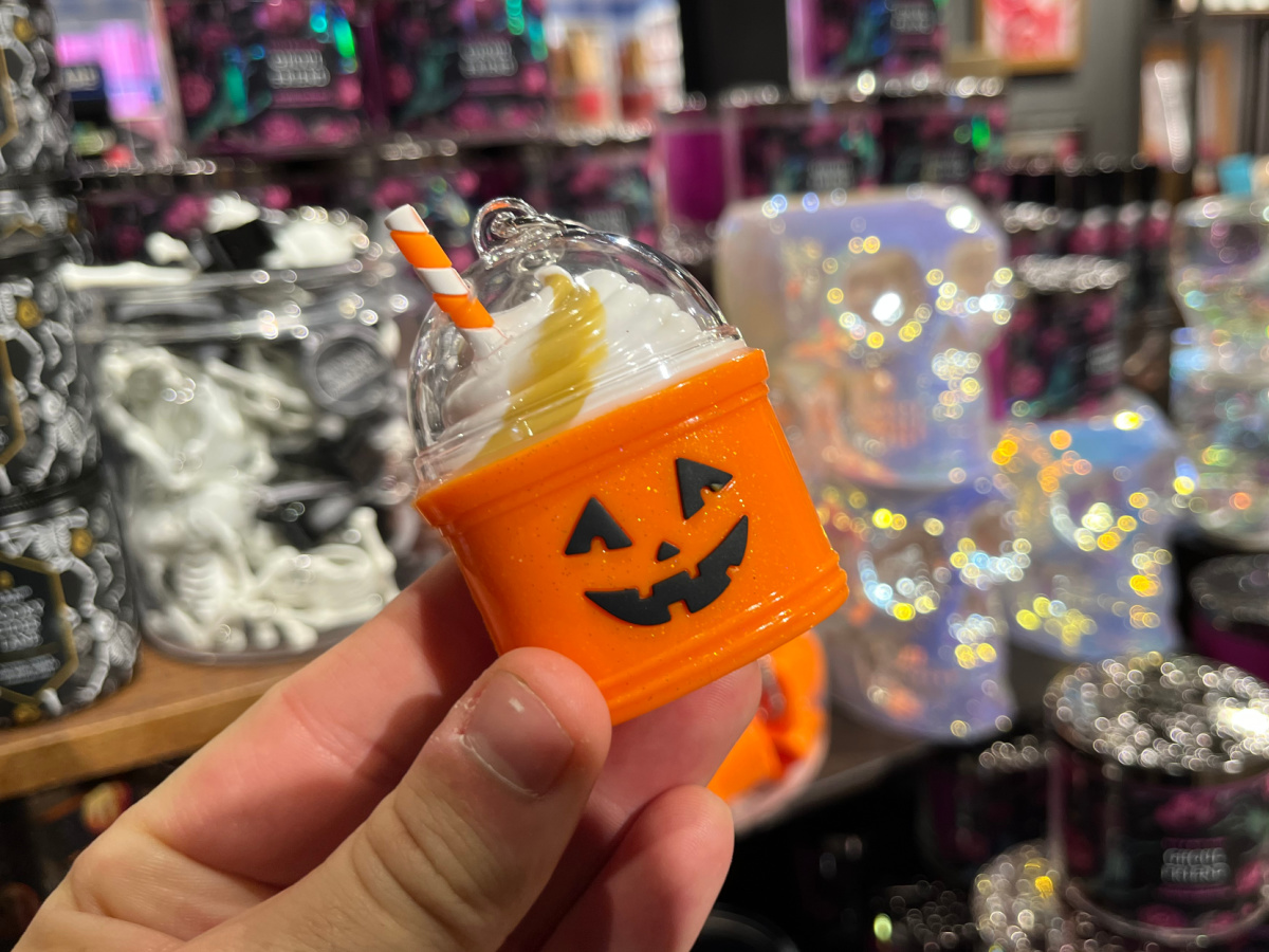 hand holding pumpkin drink hand sanitizer holder in store