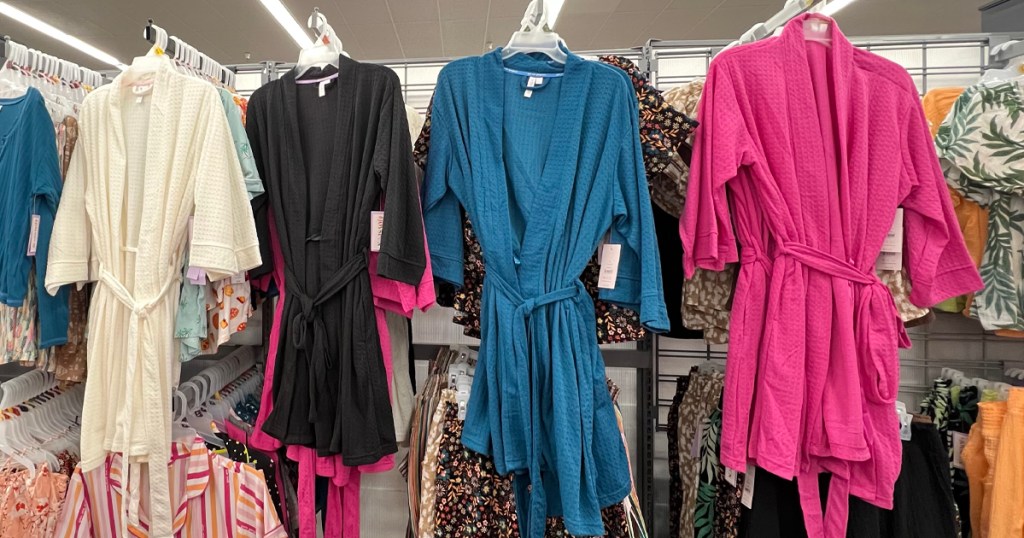 white, black, blue and pink women's waffle knit long sleeve robes hanging on display in store