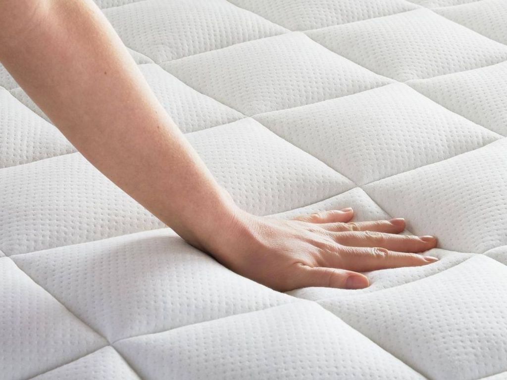 hand pressing on Lucid Mattress Cover