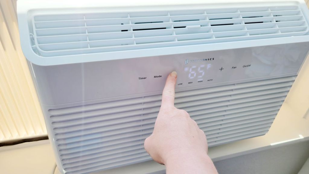 hand turning on a Taotronics air conditioner