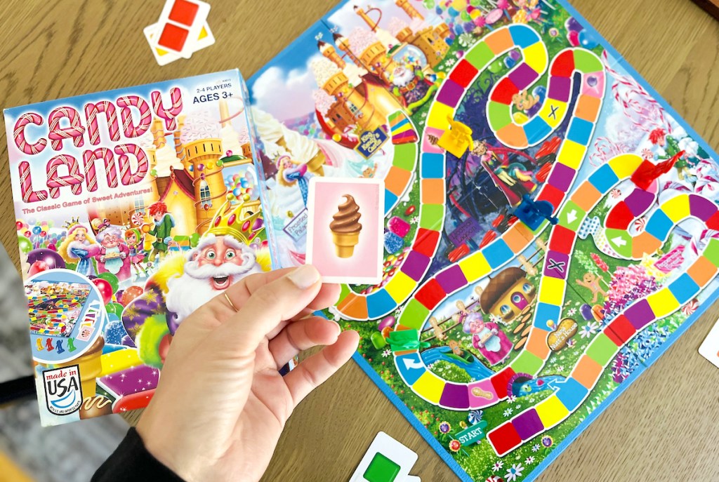 hand holding ice cream card over candy land board game for kids