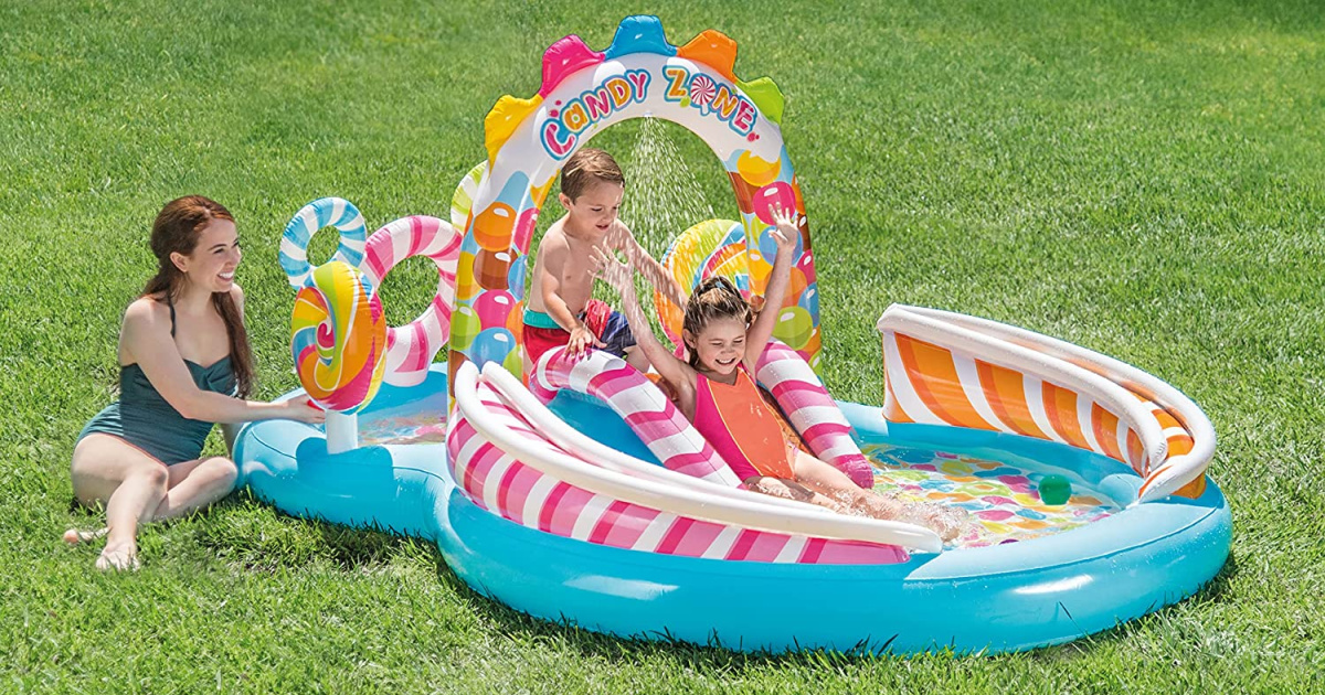 two kids playing outside on the inflatable intex candy zone play center while a woman sits next to it watching them