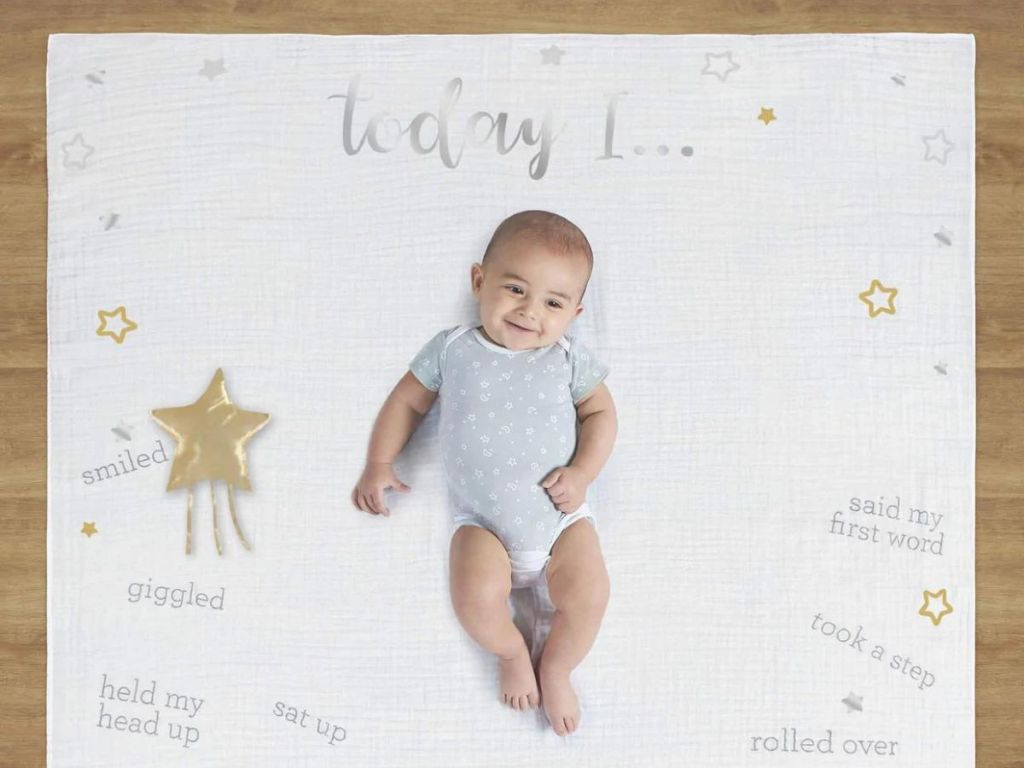 baby laying down on milestone blanket