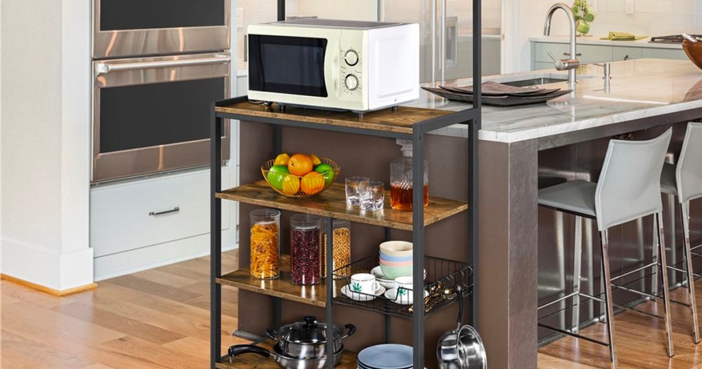metal and wood bakers rack with microwave , fruit bowls and other items on shelf