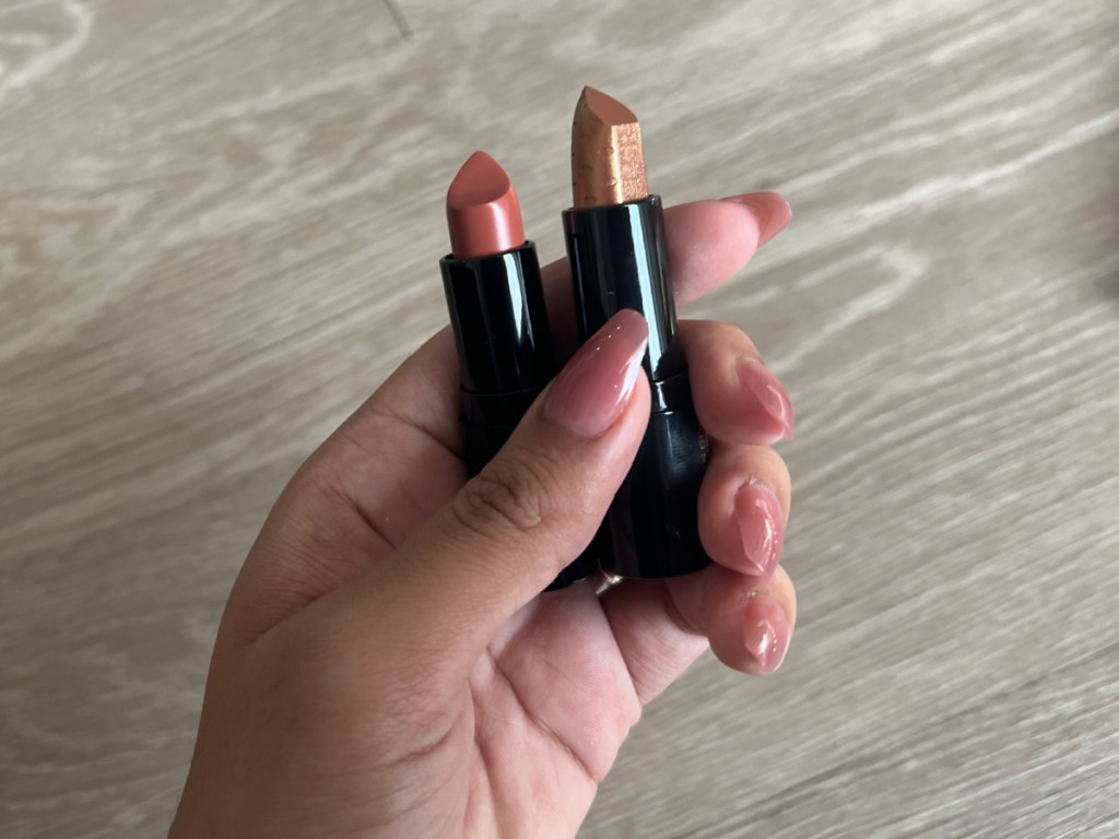 hand holding two lipsticks