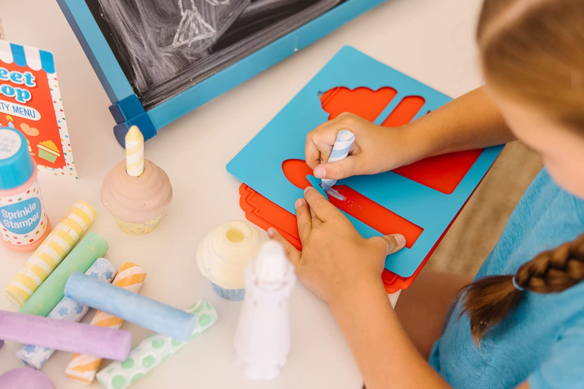 girl playing with a melissa and doug chalk set 