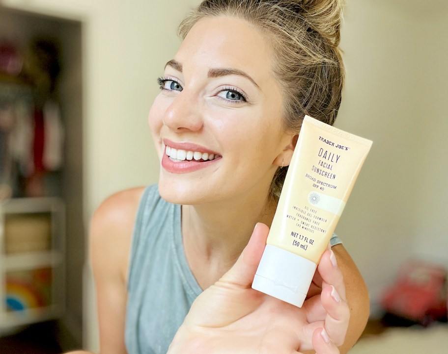 woman holding up trader joes daily facial sunscreen