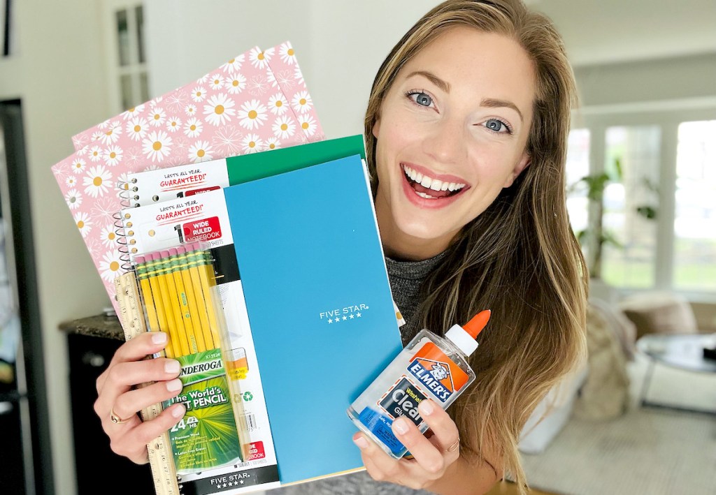 woman smiling holding up walmart school supplies