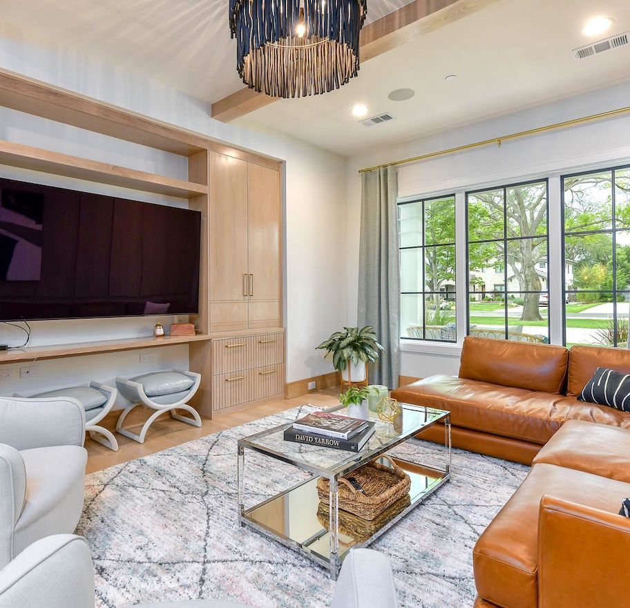 designer living room with built in cabinets and leather west elm couch sectional